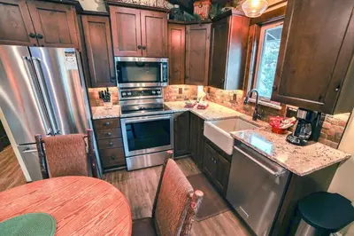 a kitchen with wooden cabinets and stainless steel appliances at Fawn Valley Inn- 269 condo in Estes Park