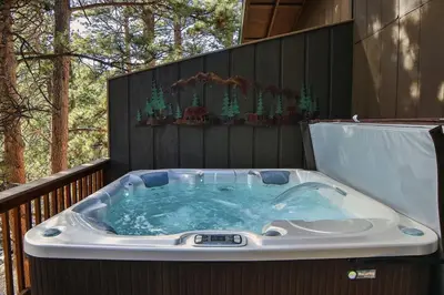 a jacuzzi tub on the deck of a house at Fawn Valley Inn- 269 condo in Estes Park