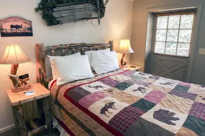 a bedroom with a bed with a quilt on it at Fawn Valley Inn- 105 condo in Estes Park
