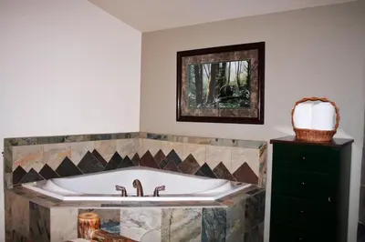 a bath tub in a bathroom with a mirror at Fawn Valley Inn- 106 condo in Estes Park