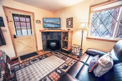 a living room with a leather couch and a fireplace at Fawn Valley Inn- 235 condo in Estes Park