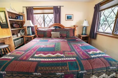 a bedroom with a bed with a colorful bedspread at Fawn Valley Inn- 235 condo in Estes Park