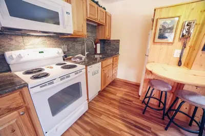 a kitchen with a white stove and a microwave at Fawn Valley Inn- 235 condo in Estes Park