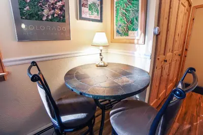 a small table with two chairs and a lamp on it at Fawn Valley Inn- 235 condo in Estes Park