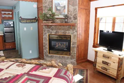 a living room with a fireplace and a television at Fawn Valley Inn- 157 cabin in Estes Park