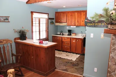 a kitchen with wooden cabinets and a counter top at Fawn Valley Inn- 157 cabin in Estes Park
