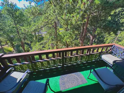 a deck with chairs and trees and trees at Fawn Valley Inn- 288 condo in Estes Park