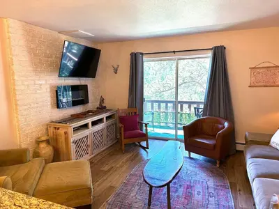 a living room with a couch and a tv at Fawn Valley Inn- 288 condo in Estes Park