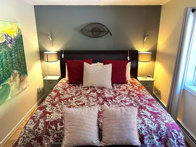 a bedroom with a bed with red and white pillows at Fawn Valley Inn- 288 condo in Estes Park