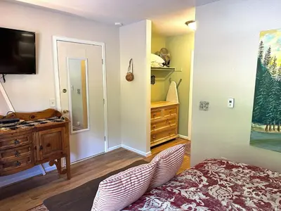 a bedroom with a bed and a dresser and a tv at Fawn Valley Inn- 288 condo in Estes Park