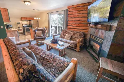 a living room with couches and a fireplace at Fawn Valley Inn- 279 condo in Estes Park