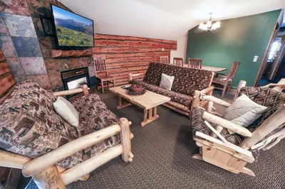 a living room with couches and a table and a fireplace at Fawn Valley Inn- 279 condo in Estes Park