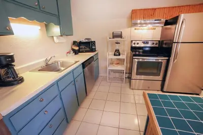 a kitchen with a sink and a refrigerator at Fawn Valley Inn- 279 condo in Estes Park