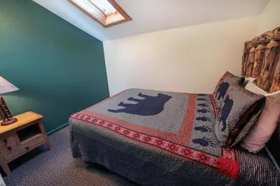 a bedroom with a bed with a blanket on it at Fawn Valley Inn- 279 condo in Estes Park