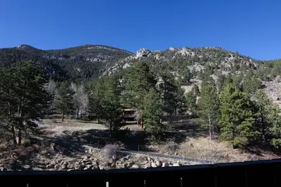 a view of a mountain with trees and a house at Fawn Valley Inn- 279 condo in Estes Park