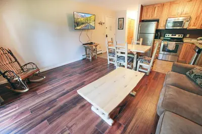 a living room with a table and a kitchen at Fawn Valley Inn- 298 condo in Estes Park