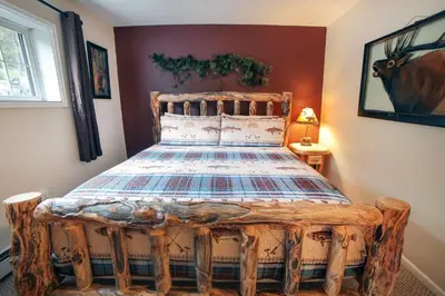 a bedroom with a bed made out of logs at Fawn Valley Inn- 298 condo in Estes Park