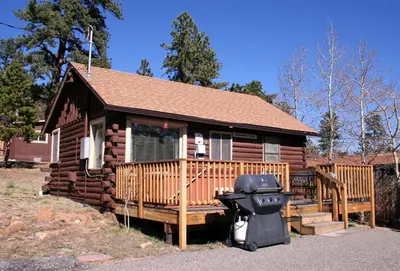 a log cabin with a motorcycle parked in front of it at Lazy R Cottages- 3 cabin in Estes Park