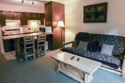 a living room with a couch and a kitchen at Fawn Valley Inn- 290 condo in Estes Park