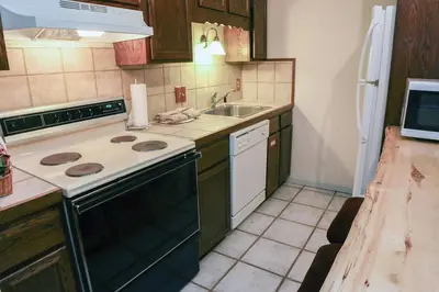 a kitchen with a stove and a sink at Fawn Valley Inn- 290 condo in Estes Park