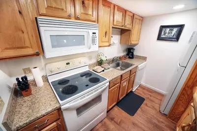 a kitchen with a stove and a microwave at Fawn Valley Inn- 205 condo in Estes Park