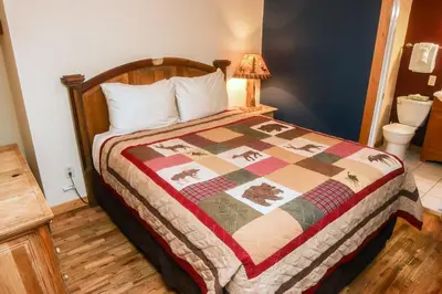 a bedroom with a bed with a quilt on it at Timber Creek Chalets- 10B chalet in Estes Park