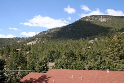 a view of a mountain with a house in the foreground at Timber Creek Chalets- 10B chalet in Estes Park