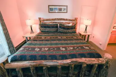 a bedroom with a large bed with two lamps at Fawn Valley Inn- 276 condo in Estes Park