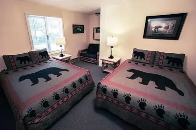 a bedroom with two beds and a living room at Fawn Valley Inn- 276 condo in Estes Park