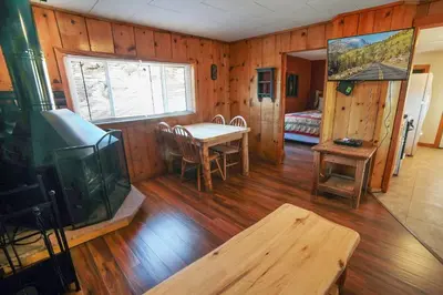 a living room with a table and a tv in it at Lazy R Cottages- 6 cabin in Estes Park