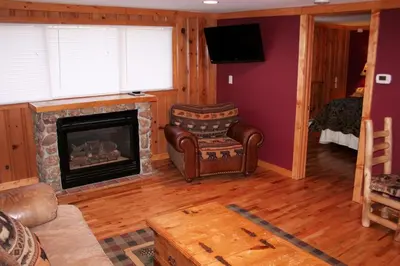 a living room with a fireplace and a chair at Timber Creek Chalets- 10A chalet in Estes Park