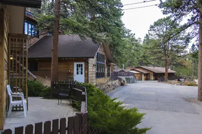 a house with a fence next to a driveway at Timber Creek Chalets- 10A chalet in Estes Park