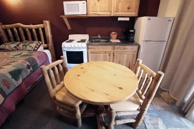 a small kitchen with a wooden table and a refrigerator at Sunnyside Knoll- 14 studio in Estes Park