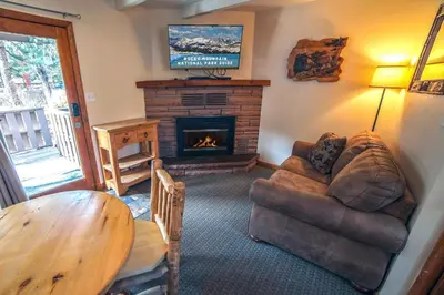 a living room with a couch and a fireplace at Sunnyside Knoll- 14 studio in Estes Park