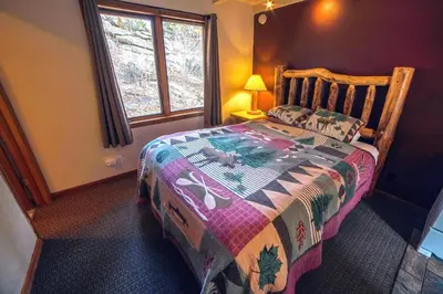 a bedroom with a bed with a quilt on it at Sunnyside Knoll- 14 studio in Estes Park
