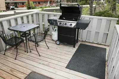 a grill on a deck with a table and chairs at Sunnyside Knoll- 14 studio in Estes Park