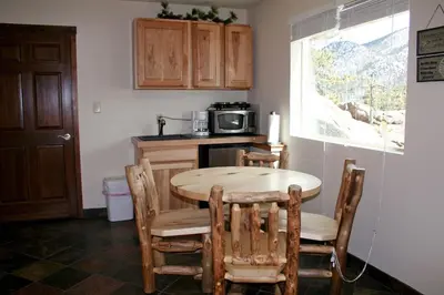 a kitchen with a table and chairs and a microwave at Lazy R Cottages- 16B cabin in Estes Park