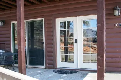two french doors on the side of a house at Lazy R Cottages- 16B cabin in Estes Park