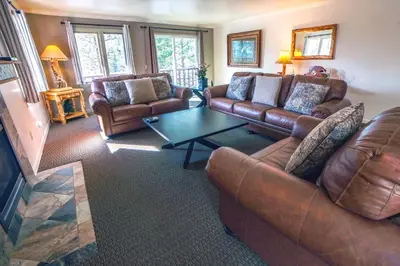 a living room with leather couches and a coffee table at Fawn Valley Inn- 275 condo in Estes Park