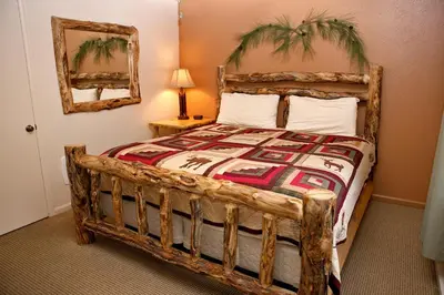 a bedroom with a large bed with a wooden frame at Fawn Valley Inn- 275 condo in Estes Park