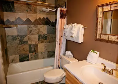 a bathroom with a toilet and a tub and a sink at Fawn Valley Inn- 275 condo in Estes Park