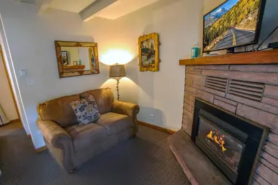 a living room with a couch and a fireplace at Sunnyside Knoll- 12 apts in Estes Park