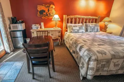 a bedroom with a bed and a table and a desk at Sunnyside Knoll- 12 apts in Estes Park