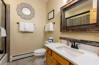 a bathroom with a sink and a toilet and a mirror at 24 Snake River Village Townhomes condo in Keystone