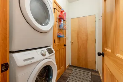a washing machine in a laundry room with a door at 24 Snake River Village Townhomes condo in Keystone
