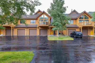 a house with a car parked in a parking lot at 24 Snake River Village Townhomes condo in Keystone