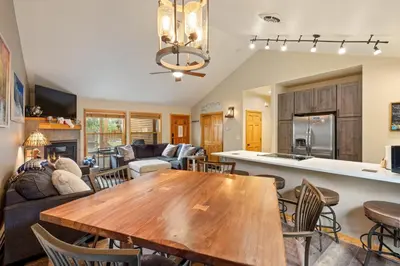 a kitchen and living room with a wooden table and chairs at 24 Snake River Village Townhomes condo in Keystone