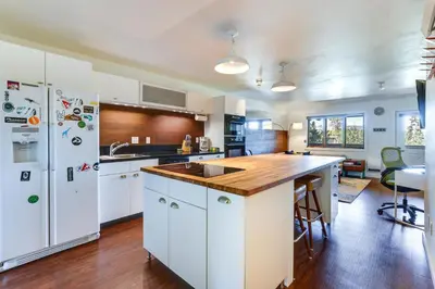 a kitchen with white cabinets and a wooden counter top at Winter Park Condo with Private Balcony Near Skiing! in Winter Park