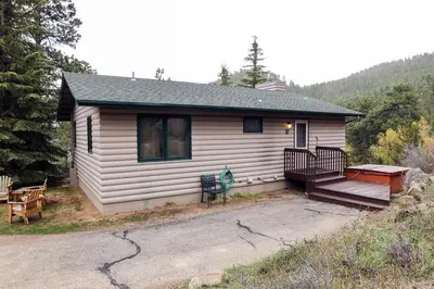 a small house with a porch and a deck at Sunnyside Knoll- 17 cabin in Estes Park