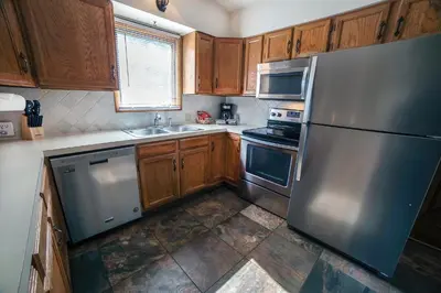 a kitchen with stainless steel appliances and wooden cabinets at Sunnyside Knoll- 17 cabin in Estes Park